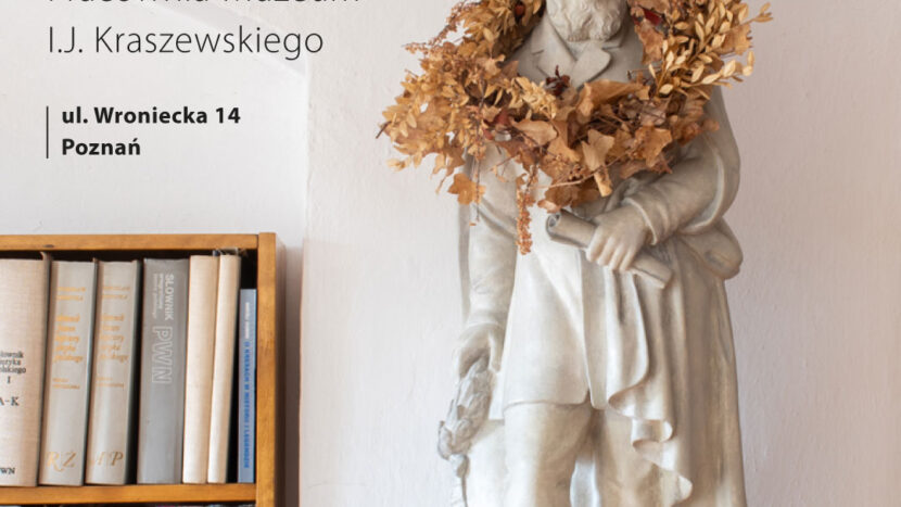 Obrazek do wydarzenia, na cokole kamienna biała figura Józefa Kraszewskiego z wieńcem z suszonych liści i ździebeł na ramionach. Obok regał z książkami.