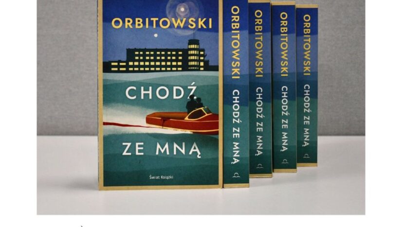 Obrazek do wydarzenia, fotografia książek Łukasza Orbitowskego, na pierwszym planie okładka z tytułm Chodź ze mną, rysunkiem motorówki i oświetlonego budynku.
