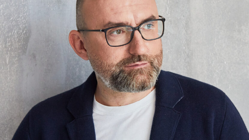 Obrazek do wydarzenia. Fotografia mężczyzny w okularach i z zarostem.