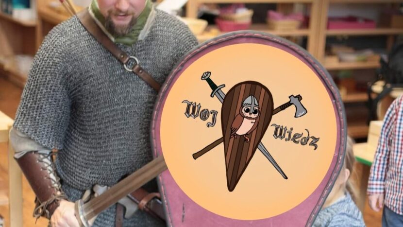 Obrazek do wydarzenia. Fotografia mężczyzny w stroju woja, ubrany w kolczugę trzyma miecz, zza niego wystają strzały.