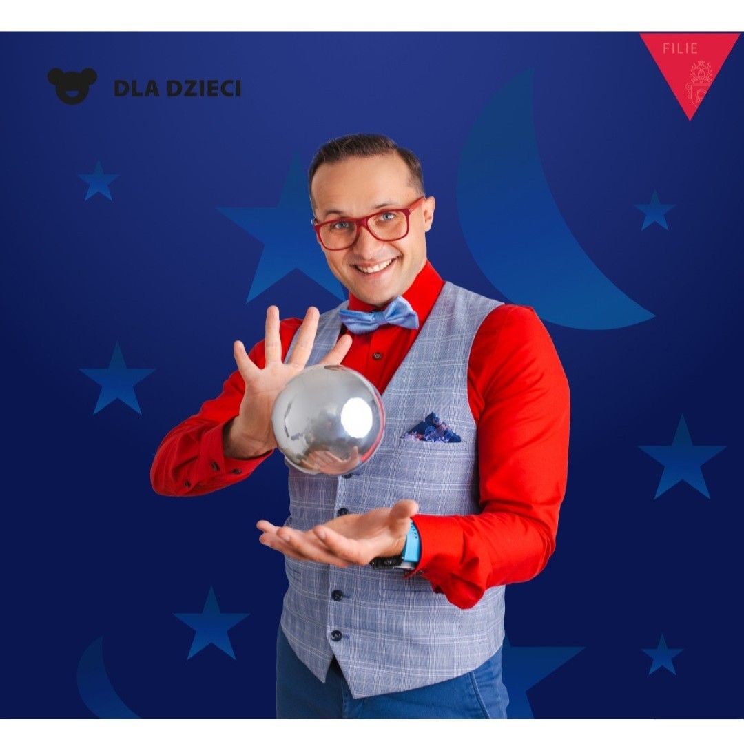 Obrazek do wydarzenia, na granatowym tle w gwiazdy mężczyzna w czerwonej koszuli i w okularach w czerwonej oprawce, ma uniesione ręce, między nimi zawieszona w powietrzu kula.