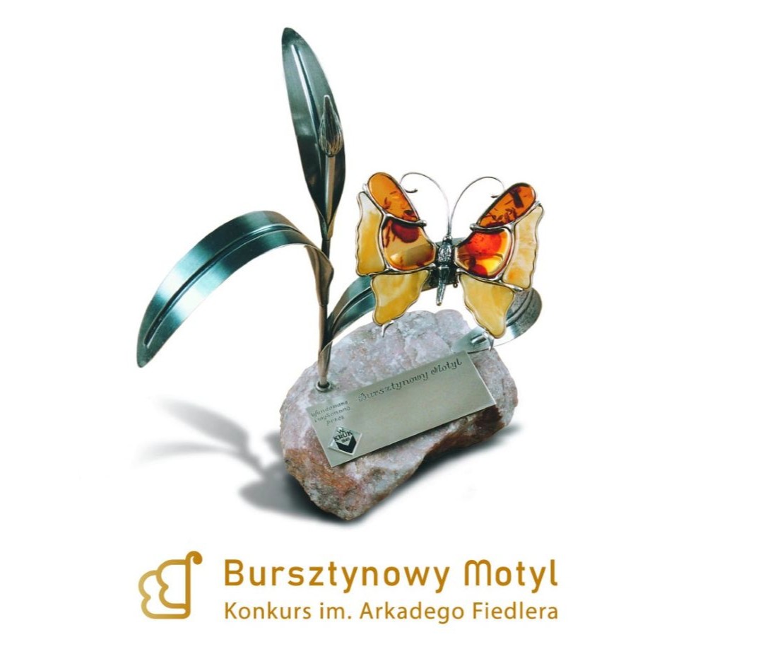 Obrazek do wydarzenia, na białym tle wizerunek statuetki, na podstawie z kamienia srebrne metalowe liście i motyl wykonany z bursztynu.